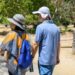 Couple going on their daily walk in a leafy suburb on a sunny summer day. Dried grass along the path. California.